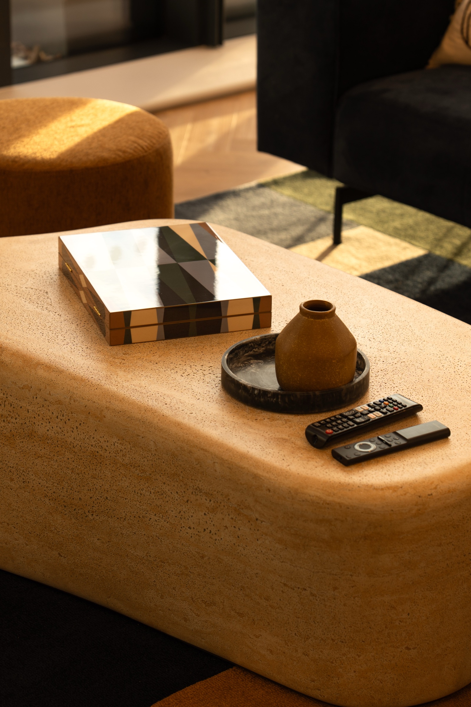 Close-up of a styled coffee table with a lacquered box, ceramic vase and tray
