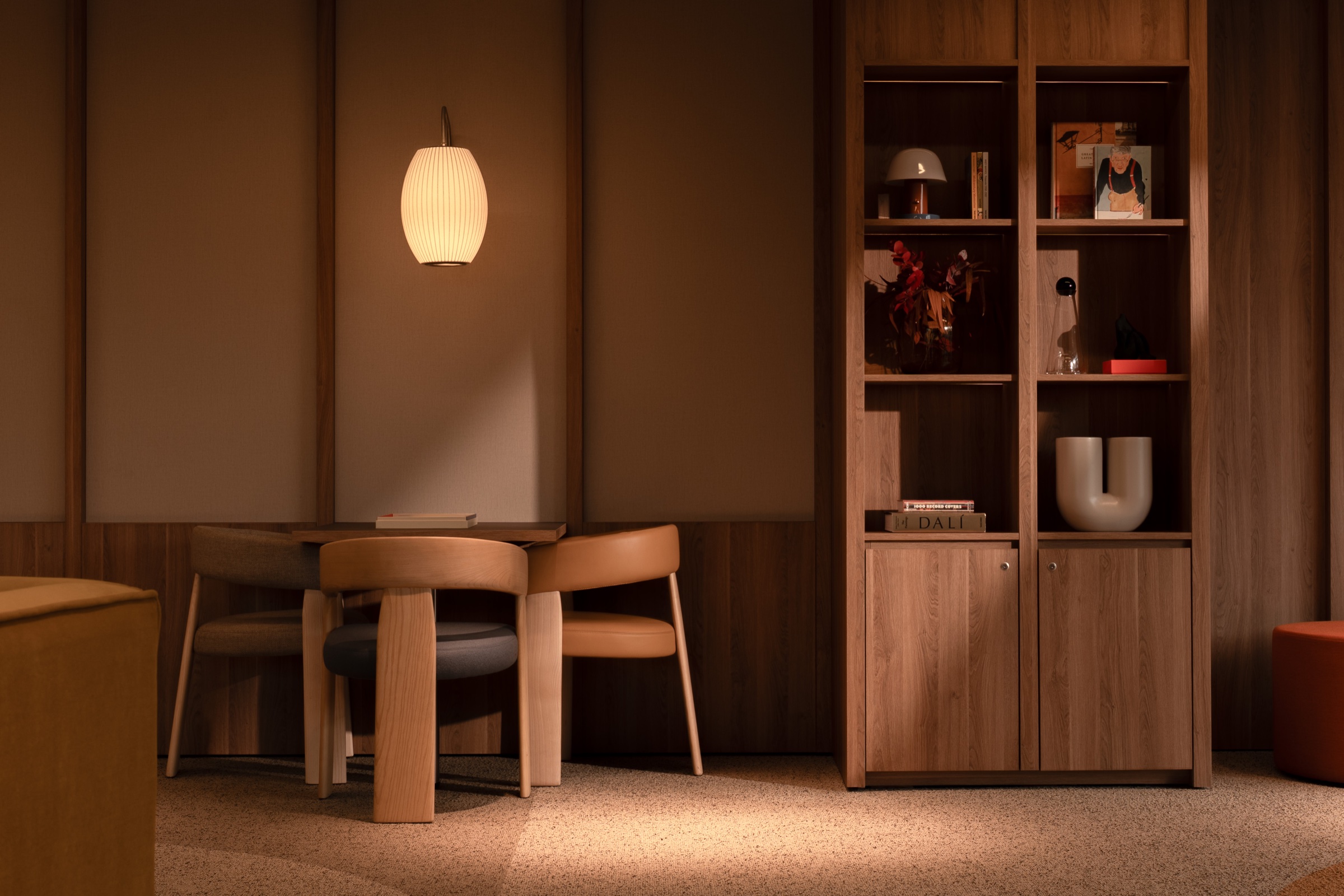 Dining nook with a pendant lamp and open wooden shelving styled with books and decor